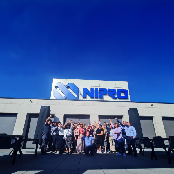 Employees pointing at Nipro logo